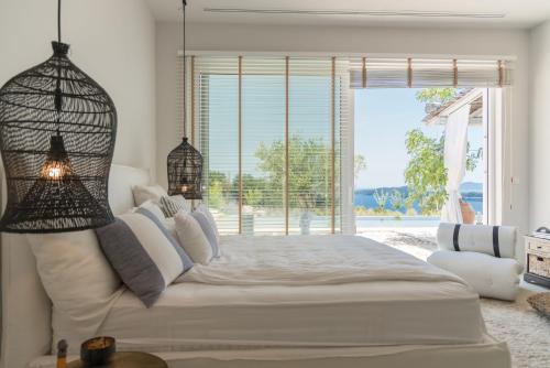 a bedroom with a large bed and a large window at Shangri-La in Meganisi