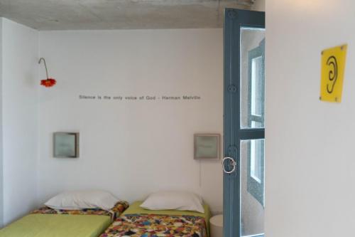 two beds in a small room with a window at ResArt Traditional House in Nicosia