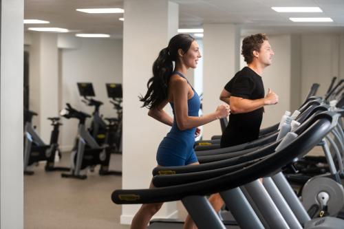 a man and a woman running on a treadmill in a gym at Aurora Anguilla Resort & Golf Club in Rendezvous Beach