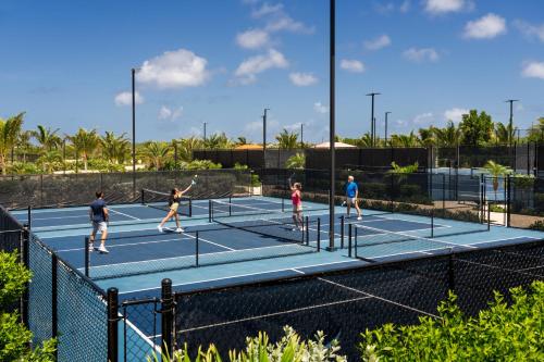 a group of people playing tennis on a tennis court at Aurora Anguilla Resort & Golf Club in Rendezvous Beach