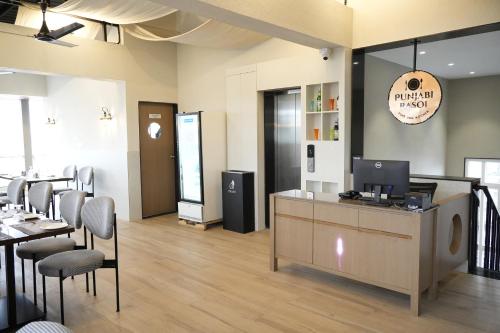 a restaurant with a counter with chairs and a table at SIVANTA by BOMBAY GROUP OF HOTELS NAGPUR in Nagpur