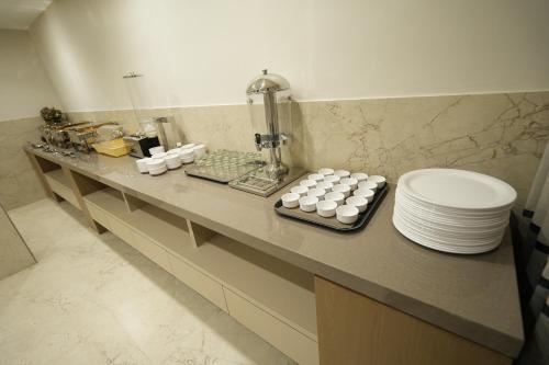 a counter top with plates and dishes on it at SIVANTA by BOMBAY GROUP OF HOTELS NAGPUR in Nagpur