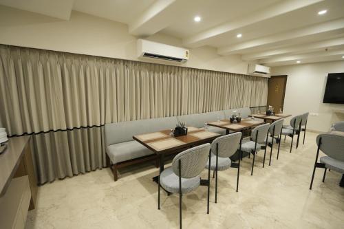 a row of tables and chairs in a restaurant at SIVANTA by BOMBAY GROUP OF HOTELS NAGPUR in Nagpur