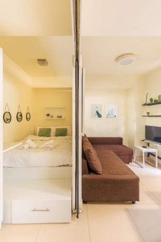 a bedroom with a bed and a couch at AIOLOS glyfada centre apartment 1 in Athens