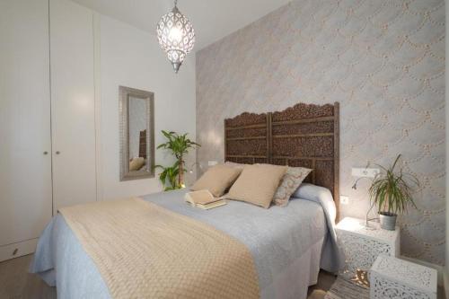 Moriscos Luxury Suite في غرناطة: غرفة نوم بسرير كبير مع لوح رأس خشبي