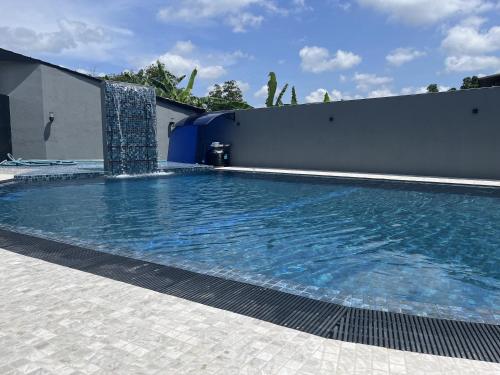 a swimming pool with a fountain in a building at Royal Crown Residency Hotel in Talawatugoda