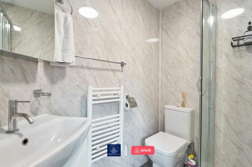a bathroom with a sink and a toilet and a shower at Last-Minute Reserve l Sleeps Up to 4 Guests l Flat 1 l One-Bedroom Apartment with King Bed and High Ceilings Near Camden by Live London Short Lets & Serviced Accommodation in London