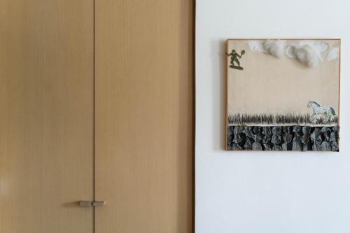a painting hanging on a wall next to a door at ResArt Traditional House in Nicosia