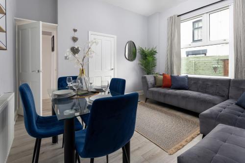 a living room with a table and blue chairs at Arkles House - Air Host & Stay - Anfield in Liverpool