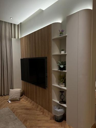 Una sala de estar con un televisor de pantalla plana en una pared. en قمه الفخامه بلكونه Luxury Apartments with balcony, en Riad