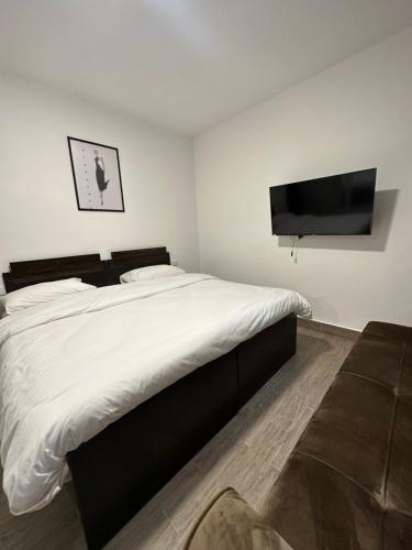 a bedroom with a large bed and a flat screen tv at central apartment for rent 16 in Umm Uthainah