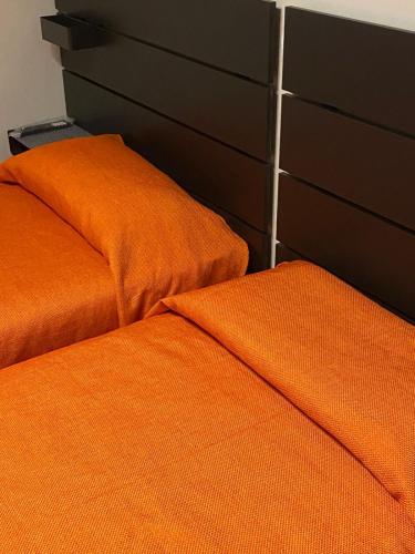 two orange pillows are sitting next to a dresser at Albergo Ristorante Plaza in Tornolo