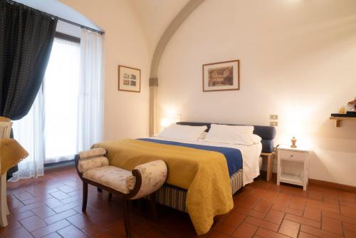 a bedroom with a bed and a chair and a window at Residence La Contessina in Florence