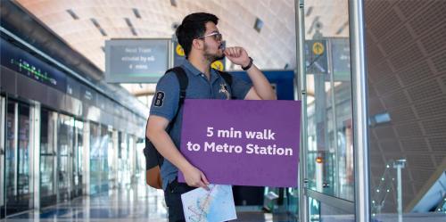 a man holding a sign that reads min walk to metro station at Premier Inn Dubai Al Jaddaf in Dubai