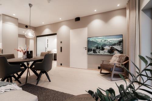 a dining room and living room with a table and chairs at Luxury penthouse apt with amazing views in Svolvær