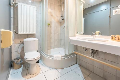 a bathroom with a toilet and a sink and a shower at Sleep & Go Menen in Menen
