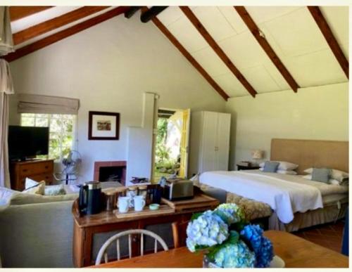 Un dormitorio con una cama y una sala de estar. en Yellowwoods Farm - POOL COTTAGE (self-catering), en Curryʼs Post