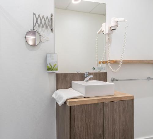a bathroom with a sink and a mirror at Sleep & Go Menen in Menen