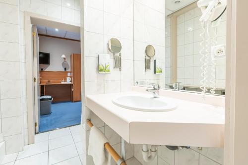 a bathroom with a sink and a mirror at Sleep & Go Menen in Menen