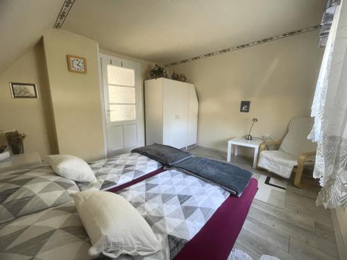 a bedroom with a bed and a white refrigerator at Heilmann Ház in Harkány