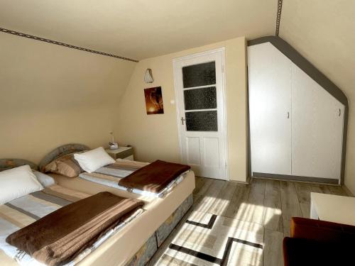 a bedroom with two beds and a window at Heilmann Ház in Harkány