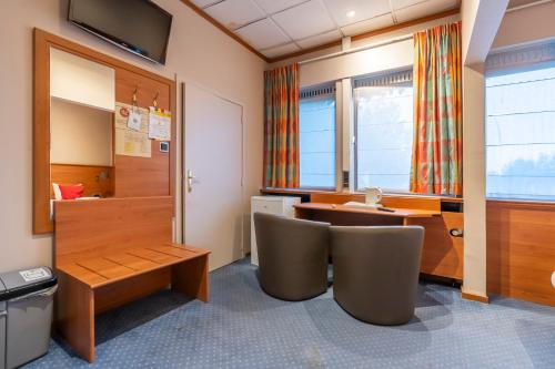 a room with a desk and two chairs at Sleep & Go Menen in Menen