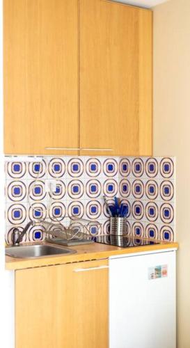 - une cuisine avec du carrelage bleu et blanc sur le mur dans l'établissement Doux Refuge - Au cœur de Paris, à Paris