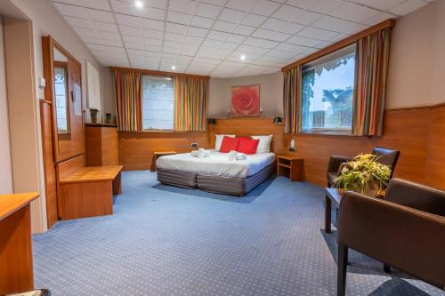 a large room with a bed and a table and chairs at Sleep & Go Menen in Menen