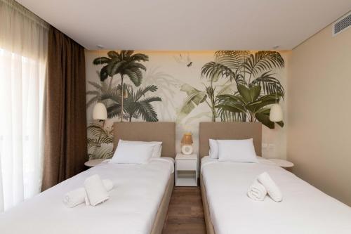 two beds in a room with plants on the wall at Sheikh Zayed New Giza Near GEM & MOA in Abū Rawwāsh