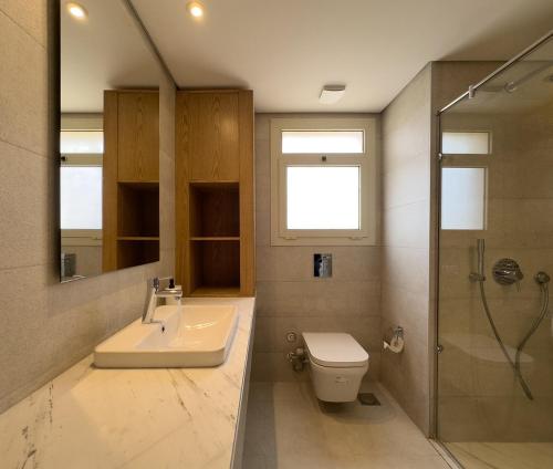 a bathroom with a sink and a toilet and a shower at Sheikh Zayed New Giza Near GEM & MOA in Abū Rawwāsh