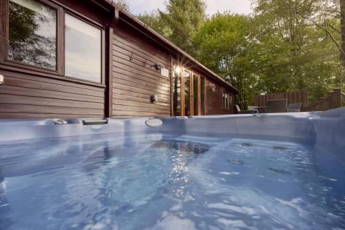 a large swimming pool in front of a house at Buzzard Lodge with Hot-tub in Carlisle