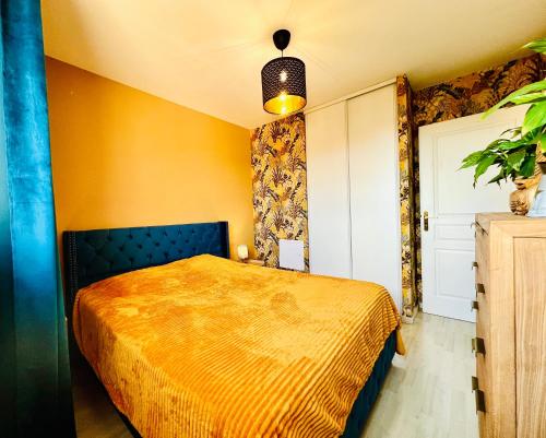 a bedroom with a bed and a yellow wall at Valenspot in Valenciennes