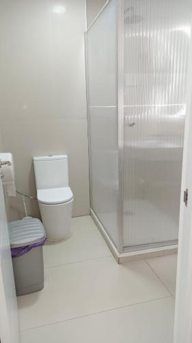a white bathroom with a shower and a toilet at Hostel Las Rosas in Madrid