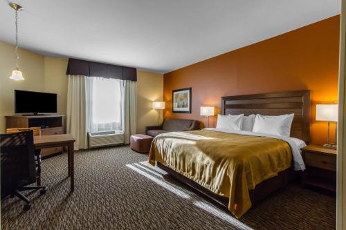 a hotel room with a bed and a television at MainStay Suites Watford City - Event Center in Watford City