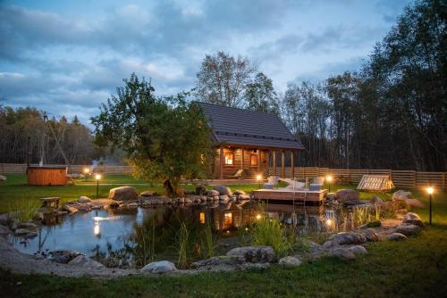 a log cabin with a pond in the yard at Jäägri Saunamaja in Parksi