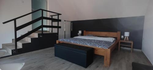 a bedroom with a bed and a black staircase at Dunavski raj in Vukovar