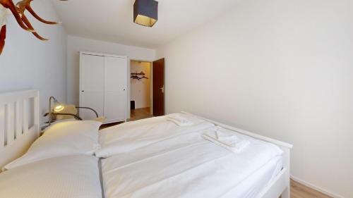 a bedroom with a white bed with white sheets at Abitaziun Landignas - Zuoz in Zuoz