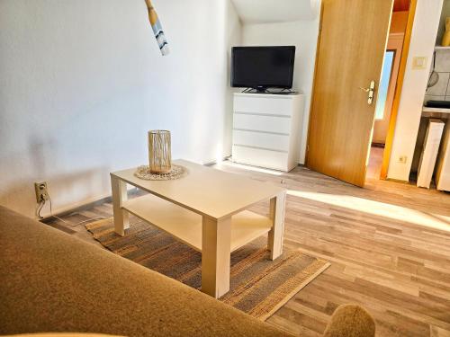 a living room with a table and a tv at Ferienwohnungen Lindenhof in Falkenberg