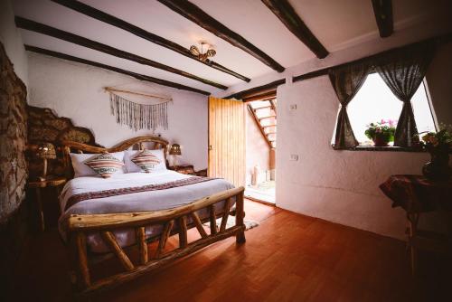 a bedroom with a wooden bed with pillows on it at Rumi Lodge Pisac in Pisac