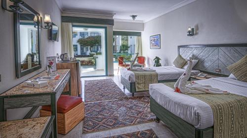 a hotel room with two beds and a desk at Falcon Hills Hotel in Sharm El Sheikh
