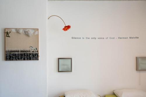 a wall with two pictures and a flower on it at ResArt Traditional House in Nicosia
