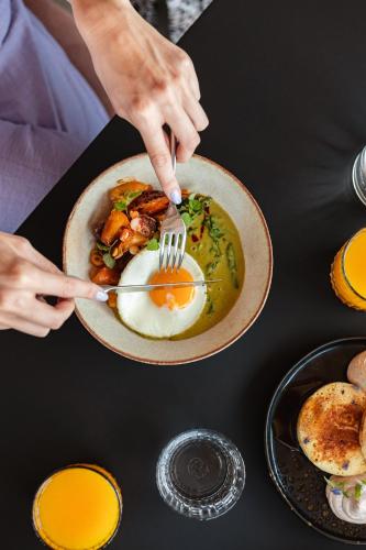 a person eating a plate of food with a fork at Hotel Rum Budapest in Budapest