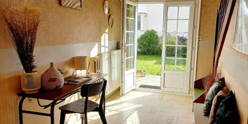 Cette chambre comprend un bureau avec une chaise et une porte. dans l'établissement Le Pavillon du Jardin des Plantes, à Le Petit-Quevilly
