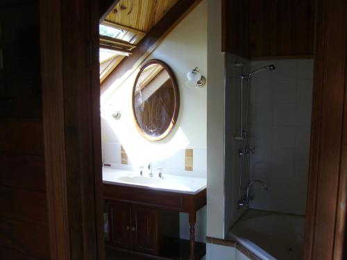 a bathroom with a sink and a round mirror at Back to the Bush in Aramara