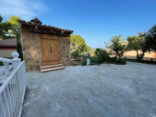 a stone building with a wooden door in a yard at Chalet El Tochar in Valencia