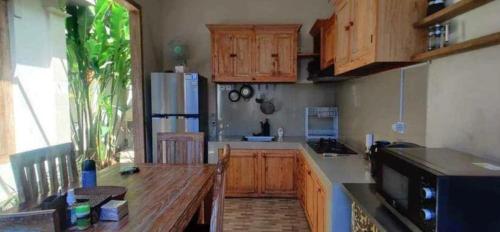 Una cocina con gabinetes de madera y una mesa de madera. en ECA Villa Sanur, en Sanur