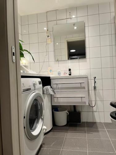 a washing machine in a bathroom with a mirror at Large Room with Balcony -two storey condo- nearby Scandic Business Center bus stop in Stavanger