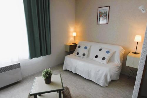 a bedroom with a white bed and a table at Sphinx Résidences - Tempologis Mémorial in Caen