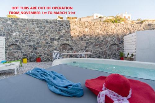 a hot tub with towels on a table next to a stone wall at LAGADI SUITES by K&K in Mesaria