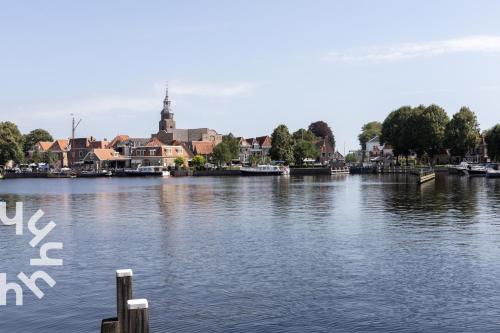 a view of a river with a town in the background at OV575 - Landelijk gelegen 2P vakantiehuis met hottub in Sint-Jansklooster in Sint Jansklooster